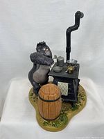 Figurine of Terk next to stove and barrel, showing left side