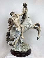 Front view of entire sculpture on wood base showing figures and horse rearing posture