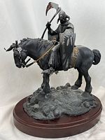 Side angle view showing warrior with axe, shield with claw marks, horseback and base with skull details.