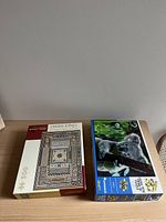 Photo showing both puzzle boxes side by side on a wooden surface, featuring the Owen Jones and 3D Koala puzzles