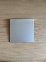 Top view of the Apple Magic Trackpad showing smooth glass surface and silver finish.