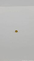 Oval cut deep canary yellow sapphire gemstone on white background.