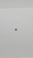 View of the natural champagne-colored zircon gemstone from a distance against a plain background.