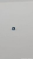 Square cut deep London blue topaz gemstone seen on a neutral light background, showing deep blue color and clarity.