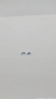 Pair of small light blue oval aquamarine gemstones on plain background, photo distance showing full stones.