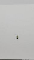 Single natural green baguette cut tourmaline gemstone placed on white background.
