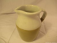 Front and side view of vintage English ceramic jug with beige and tan two-tone glaze, showing bulbous shape and pouring spout.