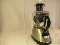 Oster food processor showing base and clear processing bowl with black handle