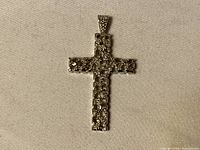Front view of sterling silver cross pendant showing clear stones set in the body and bail