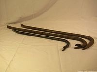 Three metal crowbars laid out on a white sheet, showing overall size and shape.