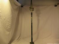 Full view of the tall metal finial showing base and pointed spear tip
