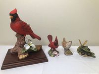 Lot overview with four different bird and butterfly figurines on a white background for scale and display.