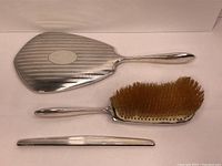 Handheld mirror, hair brush, and comb handle shown side-by-side, highlighting the set.