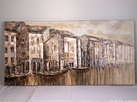 Wide view of entire canvas print showing buildings along water with reflections.