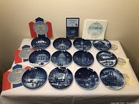 Lot of 13 Bing & Grondahl Christmas in America collector plates with certificates displayed together on a white surface.
