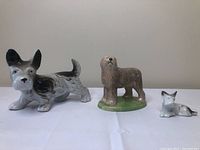Three dog figurines grouped, showing relative sizes and colors