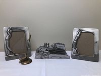 Lot showing two pewter picture frames, pewter mail holder with golfer design, and bronze colored golf club decor.
