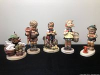 Group shot of all five figurines on black cloth