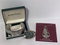 Photo showing Kirk Stieff etched flower bracelet in box, Jonquil pendant/pin with colorful inlay, and Amos Pewter sailboat pendant necklace.