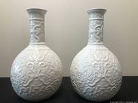 Pair of matching Spode white embossed ceramic vases seen from front showing design and shape