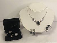 Group shot of sterling silver necklace on bust with two pairs hematite earrings on right and two pairs pearl earrings in black box on left