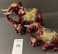 Photo showing both embroidered red elephant and calf figurines with gold and gem embellishments.