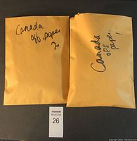 Two large Manila envelopes labeled 'Canada off paper' containing loose Canadian stamps