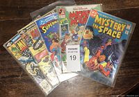 Five comic books laid out showing covers: two Marvel, two DC, one Disney Mickey Mouse