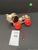 Photo of Little Snoopy toy from front angle showing head, body, wheels, and pull string.