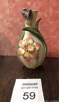Front view of Fitz and Floyd Classics Collection ceramic vase showing cream ribbed body with pink flower and green leaf decoration, flared neck with purple flower detail.