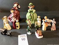 Photo showing the full set of 12 figurines arranged on dark surface with seller card.