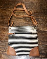 Call it Spring striped crossbody purse with tan faux leather corner accents and front zipper pocket