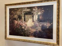 Angle view of the framed print showing the floral garden scene and ornate gold frame.
