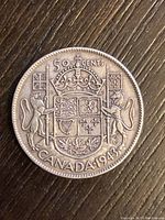 Reverse side of the 1943 Canadian 50 cent silver coin showing the Canadian Royal Arms with denomination and year.