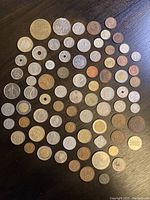 Top-down photo of approximately 56 assorted old coins in varying metals and conditions.