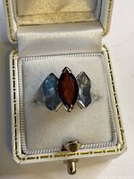 Photo of vintage sterling silver ring with marquise-cut garnet gemstone in display box, showing ring front and stone details.