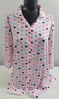 Full front view of the white nightshirt with multicoloured hearts on a mannequin, showing long sleeves and button closure.