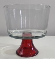 Full view of the unused glass trifle bowl showing clear bowl and red pedestal foot.