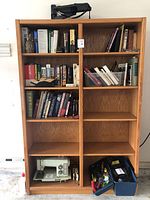 Full view of the double oak bookcase showing multiple shelves with books inside (books not included).