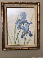 Front view of gold framed watercolor flower painting lying flat.