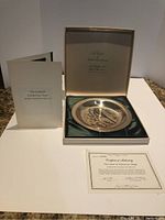 Full view of the plate inside original box with certificate and booklet included