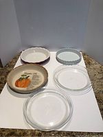 5 assorted pie plates displayed on white background, various shapes and colors shown