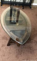 Top view of oval glass top on wooden rowboat-shaped coffee table showing interior wooden slats