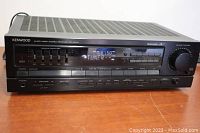 Front view of Kenwood stereo receiver powered on showing the display.