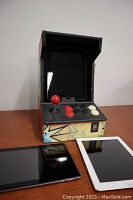 Photo of two black older iPads and the iCade arcade controller on a table