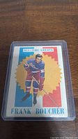 Front view of the 1960-71 Topps Frank Boucher hockey card featuring colored image and starburst background.