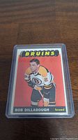 Front view of the 1965-66 Topps Bob Dillabough hockey card showing the player in Bruins uniform with red background.