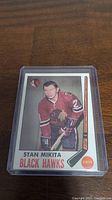 Front of the 1969-1970 Topps Stan Mikita hockey card in protective sleeve, showing player photo in Chicago Black Hawks uniform and card details.
