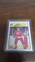 Front side of Bob Probert rookie card in plastic sleeve showing player in Red Wings uniform.