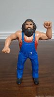Front view of LJN Hillbilly Jim wrestling figure with blue overalls and raised fists.